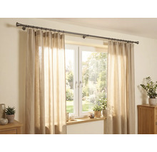 Helle Szene mit einer dunklen Vorhangstange aus Metall über einem Fenster, beigen halbtransparenten Vorhängen und Zimmerpflanzen.