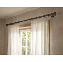 Vorhangstange aus Metall mit runden Endstücken und Vorhangringen, montiert über einem Fenster mit weißem Vorhang.