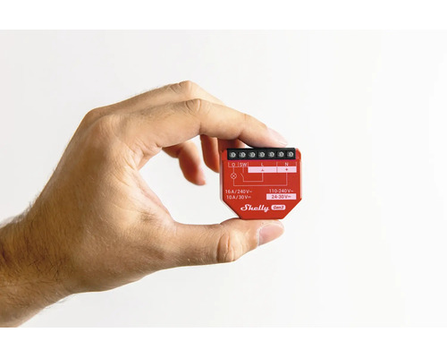 Hand hält ein Shelly Gen3 Smart Home Relaismodul zur Veranschaulichung der kompakten Bauweise.
