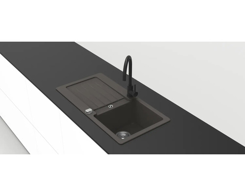 Moderne schwarze Einbauspüle aus Verbundwerkstoff mit Abtropffläche und hoher schwarzer Armatur in einer dunklen Arbeitsplatte.