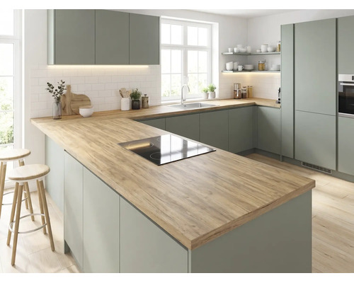 Moderne Einbauküche in Salbeigrün mit Arbeitsplatte in Holzoptik, Kochinsel inklusive Induktionskochfeld und weißen Wandfliesen.