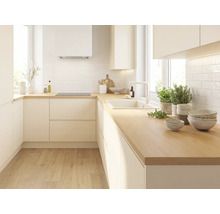 Moderne L-Küche mit hellen grifflosen Fronten, Arbeitsplatte aus Holz, weißem Fliesenspiegel, Spüle und Induktionskochfeld.