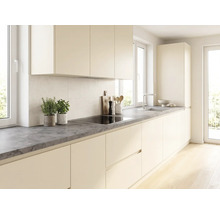 Moderne helle Küche mit grifflosen cremefarbenen Fronten, einer dunkelgrauen Arbeitsplatte in Steinoptik, Induktionskochfeld und Spüle.