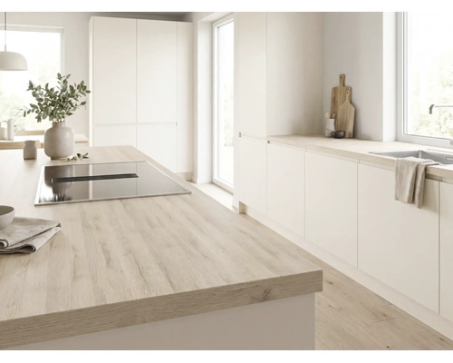 Helle Küche mit Kochinsel, Arbeitsplatte in Holzoptik, Induktionskochfeld mit integriertem Dunstabzug und weißen, grifflosen Schränken.