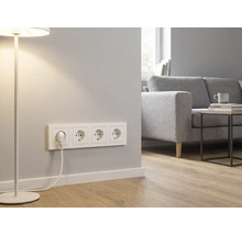 4-fach Schutzkontakt-Steckdose in einem hellen, modernen Wohnzimmer mit Sofa, Beistelltisch und Stehlampe.