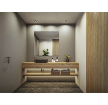 Modernes Badezimmer mit Waschtisch aus Holz, schwarzem Aufsatzwaschbecken, großem Spiegel und integrierter Beleuchtung.