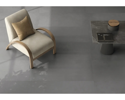 Moderner Raum mit dunkelgrauen Bodenfliesen in Steinoptik, einem minimalistischen Sessel mit Holzgestell und einem Marmorbeistelltisch.