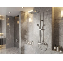 Modernes Duschsystem mit Regenduschkopf, Handbrause und Thermostatarmatur in einer gefliesten Dusche mit Steineffekt.