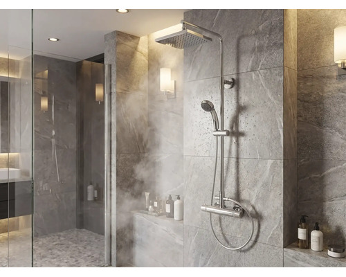 Modernes Duschsystem mit Regenduschkopf, Handbrause und Thermostatarmatur in einer gefliesten Dusche mit Steineffekt.