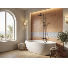 Helles Badezimmer mit freistehender Badewanne, schwarzem Duschsystem, Fliesenspiegel und großem Rundbogenfenster.