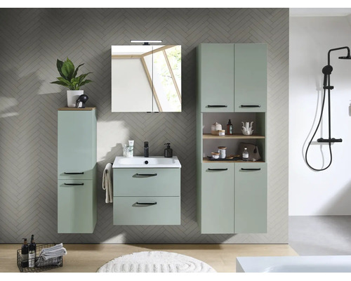 Modernes Badezimmermöbel Set in Salbeigrün mit Waschtischunterschrank, Spiegelschrank, Hochschrank und schwarzer Duscharmatur vor einer Fliesenwand.