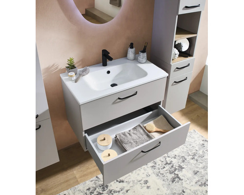 Moderner Badezimmer-Waschtischunterschrank in Grau mit weißem Keramikwaschbecken, schwarzer Armatur und offenem Auszug mit Handtüchern.