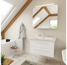 Badezimmer mit weißem Waschtischunterschrank, Keramikwaschbecken und dreitürigem Spiegelschrank mit Beleuchtung in einem hellen Dachgeschossraum.