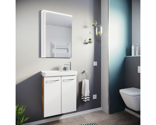 Modernes Badezimmer mit weißem Waschbeckenunterschrank, Keramikwaschbecken, LED-Spiegel und Wandtoilette. Hell und strukturiert gestaltet.