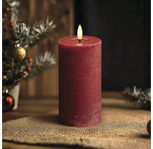 Rote LED-Stumpenkerze mit rustikaler Oberfläche und täuschend echter Flamme in einer weihnachtlichen Dekoration.