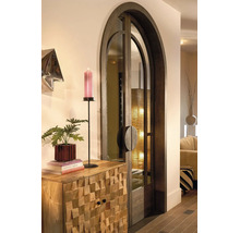 Eine elegante Rundbogentür aus dunklem Holz und Glas neben einer Kommode aus strukturiertem Massivholz mit dekorativen Objekten.