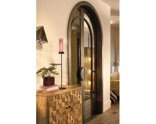 Eine elegante Rundbogentür aus dunklem Holz und Glas neben einer Kommode aus strukturiertem Massivholz mit dekorativen Objekten.