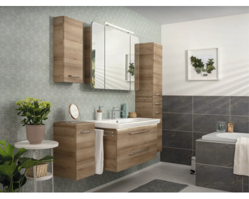 Modernes Badmöbel-Set in Holzoptik mit Waschbeckenunterschrank, Spiegelschrank und Schränken in einem hellen Badezimmer mit Fliesen und Tapete.
