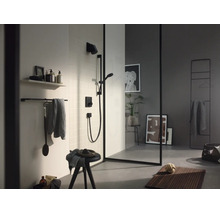 Modernes Badezimmer mit schwarzer Dusche, Glaswand mit schwarzem Rahmen, Handtuchhalter und Badematte aus Holz.