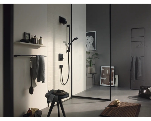 Modernes Badezimmer mit schwarzer Dusche, Glaswand mit schwarzem Rahmen, Handtuchhalter und Badematte aus Holz.