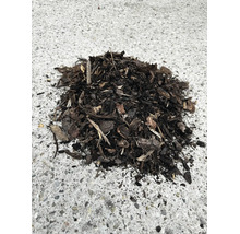 Dunkler Rindenmulch aus groben Holzstücken zur Bodenabdeckung im Garten.
