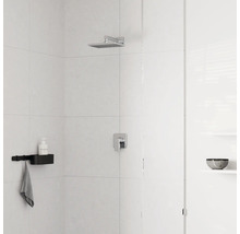 Moderne Dusche mit quadratischem Regenduschkopf aus Chrom, Einhebelmischer und schwarzer Duschablage an hell gefliester Wand.
