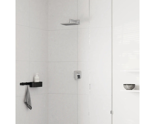 Moderne Dusche mit quadratischem Regenduschkopf aus Chrom, Einhebelmischer und schwarzer Duschablage an hell gefliester Wand.