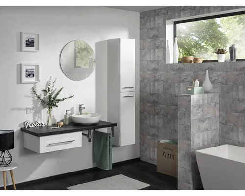 Modernes Badezimmer mit weißem Waschtischunterschrank, Aufsatzbecken, Hochschrank, rundem Spiegel und grauer Wandgestaltung in Steinoptik.