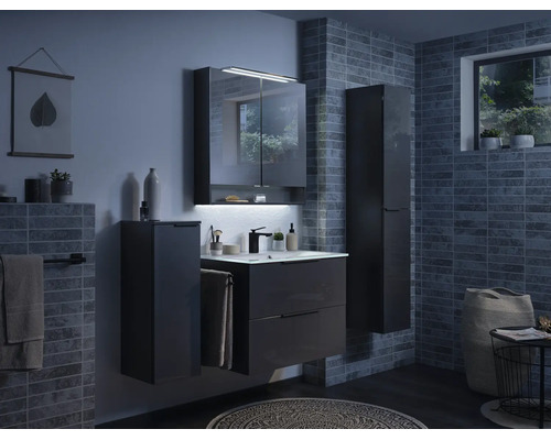 Modernes Badezimmer mit dunkelgrauem Waschtischunterschrank, Waschbecken, Spiegelschrank mit LED-Beleuchtung und Hochschränken an gefliesten Wänden.