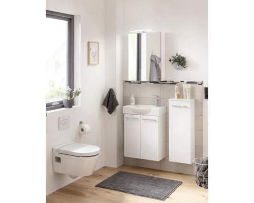 Helles Badezimmer mit weißem Waschtisch, wandhängendem WC, Spiegelschrank und Seitenschrank auf hellem Holzboden.
