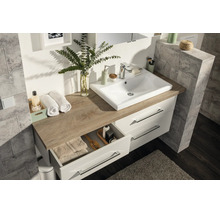 Moderner Badezimmer-Waschtisch mit weißem Aufsatzbecken, Platte in Eichenoptik und weißem Unterschrank mit zwei Schubladen.