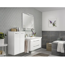 Modernes Badezimmer mit weißem Waschtisch, zwei Schubladen, passendem Hochschrank, Spiegel mit Beleuchtung und grauer Mustertapete.