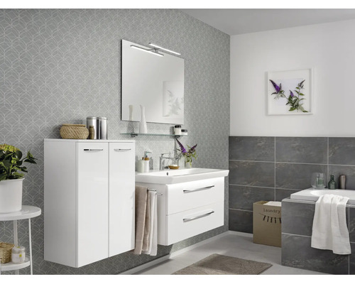 Modernes Badezimmer mit weißem Waschtisch, zwei Schubladen, passendem Hochschrank, Spiegel mit Beleuchtung und grauer Mustertapete.