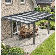 Moderne Terrassenüberdachung aus Aluminium in Anthrazit mit lichtdurchlässigem Dach auf einer gepflasterten Terrasse mit Gartenmöbeln.