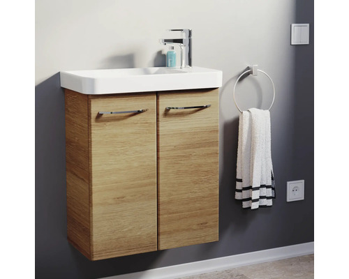 Moderner Waschbeckenunterschrank in Holzoptik mit weißem Waschbecken und verchromter Armatur in einem hellen Badezimmer.