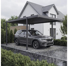 Modernes Carport aus Metall mit Flachdach vor einem Wohnhaus, schützt ein Auto auf einer gepflasterten Einfahrt.