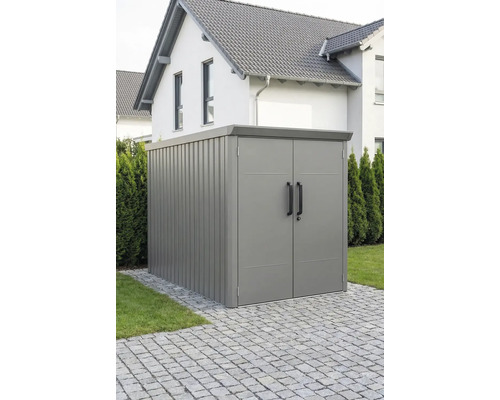 Moderner Metall-Geräteschrank mit Doppeltür und Flachdach, stehend auf einer gepflasterten Fläche im Garten.