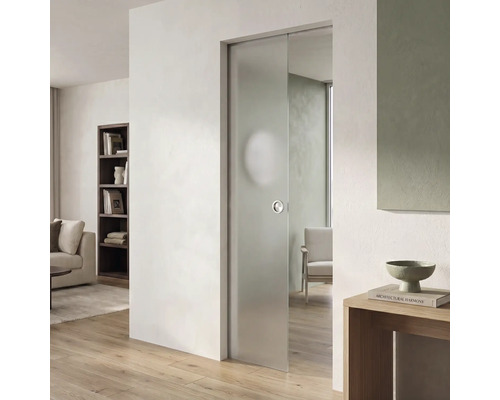 Moderne Glasschiebetür aus mattiertem Glas in einem hellen Wohnraum mit hellem Parkettboden und weißer Wand.
