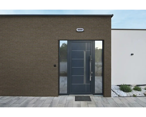 Moderner Hauseingang mit Fassade aus Verblendsteinen in Ziegeloptik und einer dunklen Haustür.
