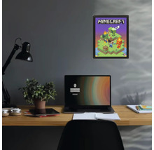 Minecraft Poster in einem schwarzen Rahmen an einer dunklen Wand über einem Schreibtisch mit Laptop und Pflanze.