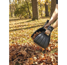 Person nutzt schwarze for_q Laubgreifer aus Kunststoff zum Aufsammeln von trockenem Laub im Garten. for_q Logo.