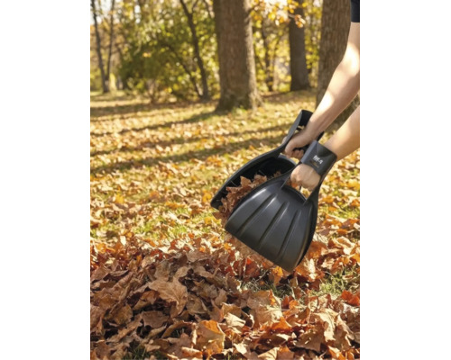 Person nutzt schwarze for_q Laubgreifer aus Kunststoff zum Aufsammeln von trockenem Laub im Garten. for_q Logo.