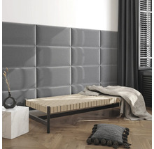 Modernes Zimmer mit rechteckigen Polsterpaneelen an der Wand über einer Liege mit hellem Fischgrät-Holzboden.