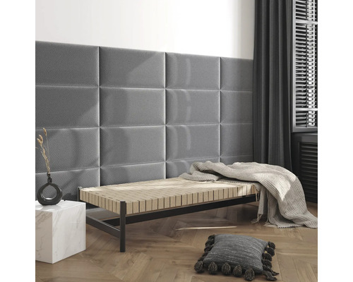 Modernes Zimmer mit rechteckigen Polsterpaneelen an der Wand über einer Liege mit hellem Fischgrät-Holzboden.