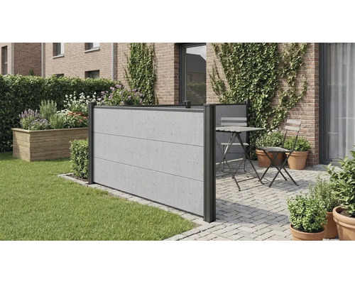 Moderner Sichtschutzzaun in Betonoptik auf einer gepflasterten Terrasse neben einer Rasenfläche mit Sitzgruppe und bepflanzter Ziegelwand.