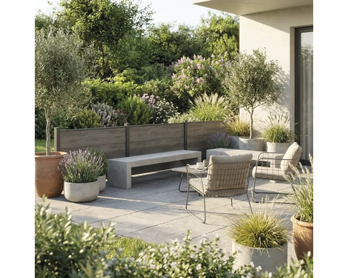 Moderne Terrassengestaltung mit hölzernem Sichtschutzzaun, Sitzbank in Betonoptik, Metallstühlen und verschiedenen Kübelpflanzen in heller Umgebung.