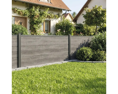 Moderner Sichtschutzzaun in Anthrazit mit Holzstruktur in einem gepflegten Garten mit Rasenfläche.