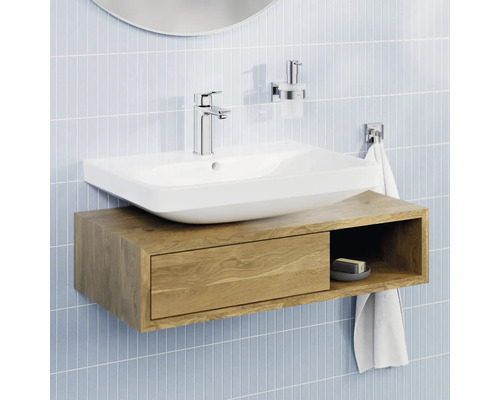 Helles Badezimmer mit weißem Aufsatzwaschbecken auf einem wandhängenden Waschbeckenunterschrank aus Holz mit Schublade und offenem Fach.