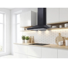 Moderne, helle Küche mit schwarzer Kamin-Dunstabzugshaube über einem Induktionskochfeld, weißem Fliesenspiegel und Arbeitsplatten in Holzoptik.