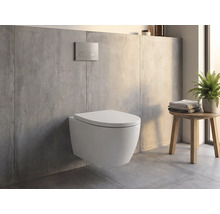 Wandhängendes WC in einem modernen Badezimmer mit Betonoptik, Betätigungsplatte an der Wand und einem Holzhocker mit Handtüchern und Pflanze.